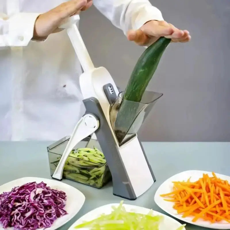 Manual vegetable cutter with adjustable blades slicing a cucumber, featuring compartments for collecting chopped vegetables. Ideal for safe and efficient food prep.