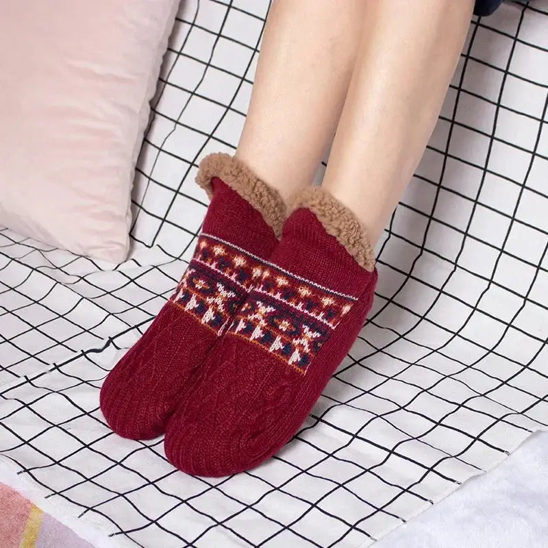 Red fuzzy slipper socks with festive pattern worn